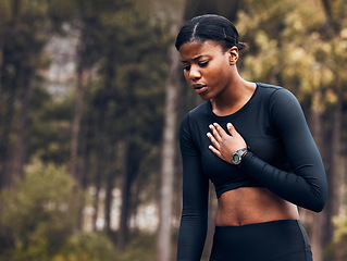 Image showing Tired, asthma and black woman athlete with breath problem while running, training or exercise and a chest pain. Cardio, forest and young female person or runner with heart attack risk or injury