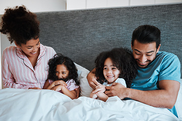 Image showing Love, bonding and children laying with their parents in their bedroom playing, tickling and laughing. Happy, smile and girl kids being playful and relaxing with their mother and father in the bedroom