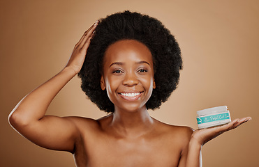 Image showing Portrait, hair and curl treatment with a black woman in studio on a brown background for cosmetics. Face, smile and haircare product in the palm of a happy female model for natural afro hairstyle