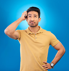 Image showing Thinking, ideas and confused man brainstorming promo, problem solving plan or commercial strategy. Planning, space and studio person with questions, decision or doubt choice on blue background