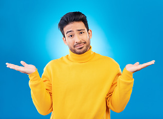 Image showing Doubt, shrug and portrait of a man in a studio with a confused hand gesture and facial expression. Uncertain, choice and male model with questions or decision face isolated by a blue background.