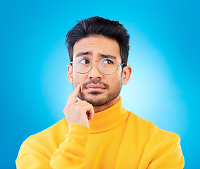 Image showing Thinking, face or studio man planning solution, problem solving inspiration or doubt idea, question or confused. Mindset, wonder or person brainstorming options, decision or choice on blue background