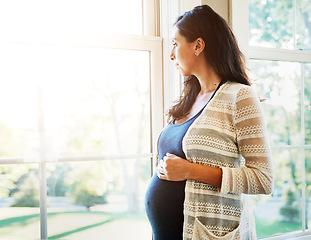 Image showing Woman, pregnant and thinking on future at window, hope and maternity, love and hands on stomach. Mother, healthy and care for baby, prenatal wellness and support in motherhood, home and family