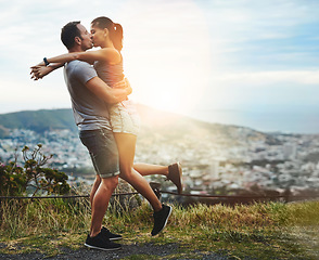Image showing Kiss, lift or happy couple hug in nature for outdoor date, love or trust with support, bond or freedom. Romantic man, care or woman excited by holiday vacation together to celebrate, relax or travel