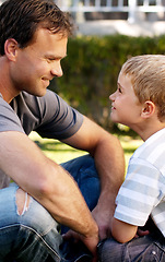 Image showing Smile, father and boy sitting on grass, cute bonding together with care and love in home backyard. Outdoor fun, dad and child on lawn in garden, playful with trust and support with happy man and son.