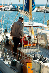 Image showing Travel, yacht and man sailor on the ocean for coastal vacation, adventure or holiday in summer. Nature, sailing and senior male person working on sailboat with a dog on sea for tropical weekend trip.