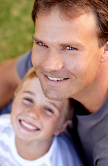 Image showing Portrait, happy man and son sitting on grass, cute bonding together with care and love from above. Fun, father and child on ground in backyard of home with smile, trust and support with dad and boy.