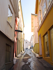 Image showing Snow, street and buildings at a village in Norway in winter outdoor for travel, vacation in Europe or tourism holiday in vintage city. Road, architecture and houses, home exterior or alleyway in town