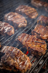 Image showing Steaks are in various stages of cooking