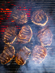 Image showing Steaks are generously covered in seasoning