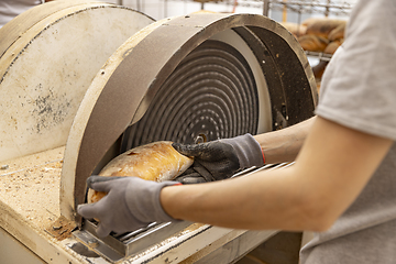 Image showing Worker grate bread crust in factory