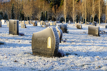 Image showing frozen graveyard with tombstones in sunlight