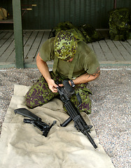 Image showing Military, training to assemble a gun with a man soldier outdoor in camouflage uniform for an exercise. Army, blindfold and a trooper person at bootcamp to build a weapon or rifle in record time