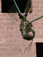 Image showing Army, soldier and training with rope obstacle for fitness, exercise or challenge outdoor upside down. Military, man and climbing with physical workout, mission or bootcamp for survival from building