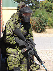 Image showing Soldier, man and target by building with weapon for fitness, exercise or challenge outdoor with gear. Military, person or battle for workout, mission or bootcamp with camouflage or mask for survival