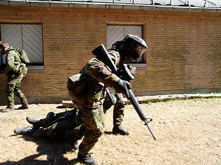 Image showing Army, soldier and mission by building with weapon for fitness, exercise or challenge outdoor with gear. Military, people and running for workout, training or bootcamp with camouflage for survival