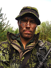 Image showing Soldier, portrait and man in field with rifle for fitness, exercise or challenge outdoor with gear. Military, army person or battle for mission or bootcamp with camouflage and gun weapon for survival