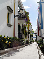 Image showing Street, buildings and houses in the city for vacation, adventure or travel in Greece. Summer, flowers and homes in the road with a path for walking, village alley or architecture in a local town