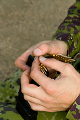 Image showing Man, soldier hands and bullet for a gun outdoor with military training, battle and conflict. Army, war and field with a male tactical expert of a hero with weapon for shooting range and warrior gear