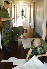 Image showing Army, war and map with a soldier team planning a battle strategy in the hallway of their military base. Training, teamwork and camouflage with personnel getting ready for problem solving in uniform