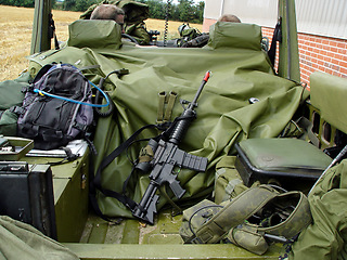 Image showing Soldiers, vehicle and military equipment for mission, objective or outdoor hunt with gun, ammunition or storage. People or army at base with truck for firearm, rifle or supplies ready for rendezvous