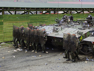 Image showing Military, tank and support with soldier people training outdoor at bootcamp, getting ready for war. Army, safety and riot patrol with a cadette group on a security mission in camouflage uniform