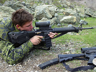 Image showing Soldier, sniper and man with a weapon, military and war with combat, fighting and battlefield with conflict. Person, warrior or guy on the ground, gun or shooting at target with army, outdoor or hero