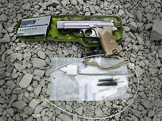 Image showing Military, weapon and handgun with cleaning kit on ground outdoor for service, mission or protection of soldier. Pistol, sniper or gun for maintenance, danger or shooting on battlefield or operation
