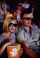 Image showing Cinema, 3d glasses and couple with popcorn, watching film or eating on romantic date together. Movie night, man and woman in theater with snacks, eyewear and sitting in auditorium to relax at premier