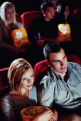 Image showing Cinema, watching and couple with popcorn, film and eating on romantic date together. Movie night, man and woman in theater with snacks, entertainment and sitting in auditorium to relax at premier.