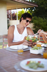 Image showing Happy man, salad and garden with meal and food in summer with teen and health for eating. Table, backyard and young male person with a smile and sunglasses on vacation with lunch outdoor of a home