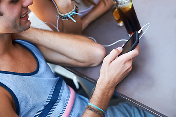 Image showing Smile, cafe and a man with a phone for music, listening to a podcast or watching a video. Happy, social media and a person with a mobile for a radio app, sound or streaming audio at a restaurant