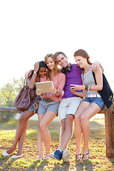 Image showing Happy, hug and friends in a park with tablet for social media, streaming or music subscription search. Students, diversity and gen z group outdoor bond, relax or check digital app for meme or chat
