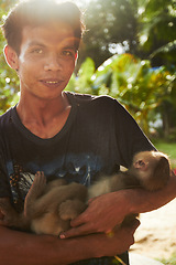 Image showing Zoo, nature and portrait of man with monkey for care, conservation and wildlife rescue. Sanctuary, travel and happy person with macaque in environment, ecosystem and animal park for Thailand tourism