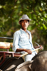 Image showing Indian, man and portrait of trainer riding on back of elephant for wildlife, animal rescue and outdoor. Sanctuary, face and person in nature for transportation, adventure or conservation in forest