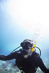 Image showing Person, swimming and scuba diving in ocean to explore underwater, adventure and tropical holiday or vacation. Expert diver in Maldives with mockup space, nature and bubbles in water for sea life
