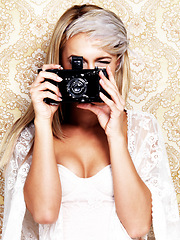 Image showing Portrait, camera and a bride in a wedding dress on a floral pattern in studio to photograph her ceremony. Fashion, marriage and a young woman with retro or vintage photography equipment for memory