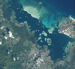 Image showing Ocean, nature and aerial of earth for map with city landscape, environment and coast line. Geography, planet and satellite, top view and atmosphere of sea, buildings and clouds for travel destination