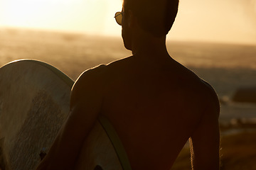 Image showing Man, beach and surf, sunset and silhouette with back view, sport and travel, adventure and fitness in nature. Ocean, orange and peace with freedom, workout on summer vacation and surfboard outdoor