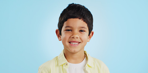 Image showing Face, boy child and smile in studio for wellness and confidence on a blue background with positive mindset. Portrait, kid and happiness with casual fashion, joyful and relaxed expression on mockup