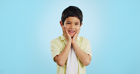 Image showing Excited, kid and hands on face for surprise in studio isolated on a blue background mockup space. Portrait, wow and happy child shocked at good news, information announcement and facial expression.