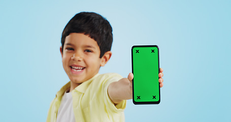 Image showing Kid, face or phone green screen in studio on social media for ecommerce, tech or download app logo. Blue background, space or happy child with notification for online marketing, mockup or advertising