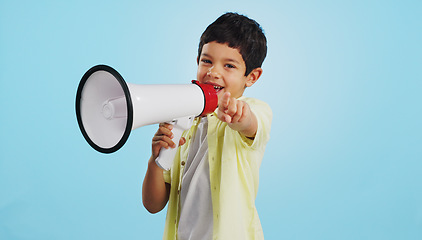 Image showing Communication, face or child with megaphone for news, opinion or sale announcement on blue background. Happy, pointing or young boy talking on loudspeaker for voice, speaking or attention in studio