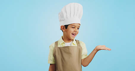 Image showing Child, happy face and chef hand to show promotion, advertising or deal in studio. Dress up, profession and young boy happy from future career of cooking and open palm for sale with blue background