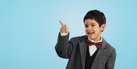 Image showing Pointing, face or happy child in studio for offer, discount deal or retail sale on mockup space or logo advertising. Business, funny or excited boy with smile, news or kids promo on blue background