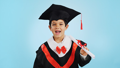 Image showing Graduate, child and celebration with portrait and happiness in studio on blue background for education. Development, kid and success with excited expression, diploma or certificate for achievement