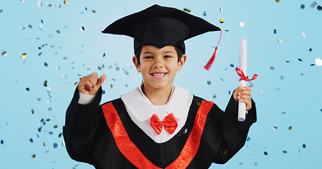 Image showing Graduate, child and celebration with confetti and happy dance in studio on blue background for education. Development, kid and success with excited expression, diploma or certificate for achievement