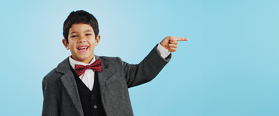 Image showing Pointing, face or happy child in studio for offer, discount deal or retail sale on mockup space or logo advertising. Business, funny or excited boy with smile, news or kids promo on blue background