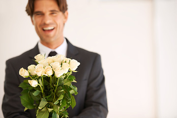 Image showing Portrait, gift and happy man with flowers for love, giving or valentines day celebration on wall background. Face, roses and person with bouquet for anniversary, romance or congratulations gesture