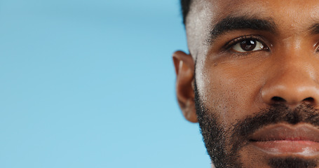 Image showing Half, face and serious black man in studio, blue background and mockup space with confidence or advertising. Portrait, closeup and marketing for skincare, wellness or healthy dermatology care